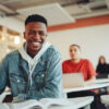 African student sitting in classroom. Male student smiling during the lecture in high school classroom.